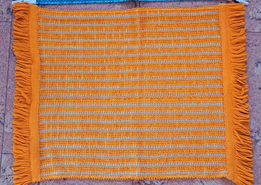 A fringed sauna seat towel in a vintage orange fabric